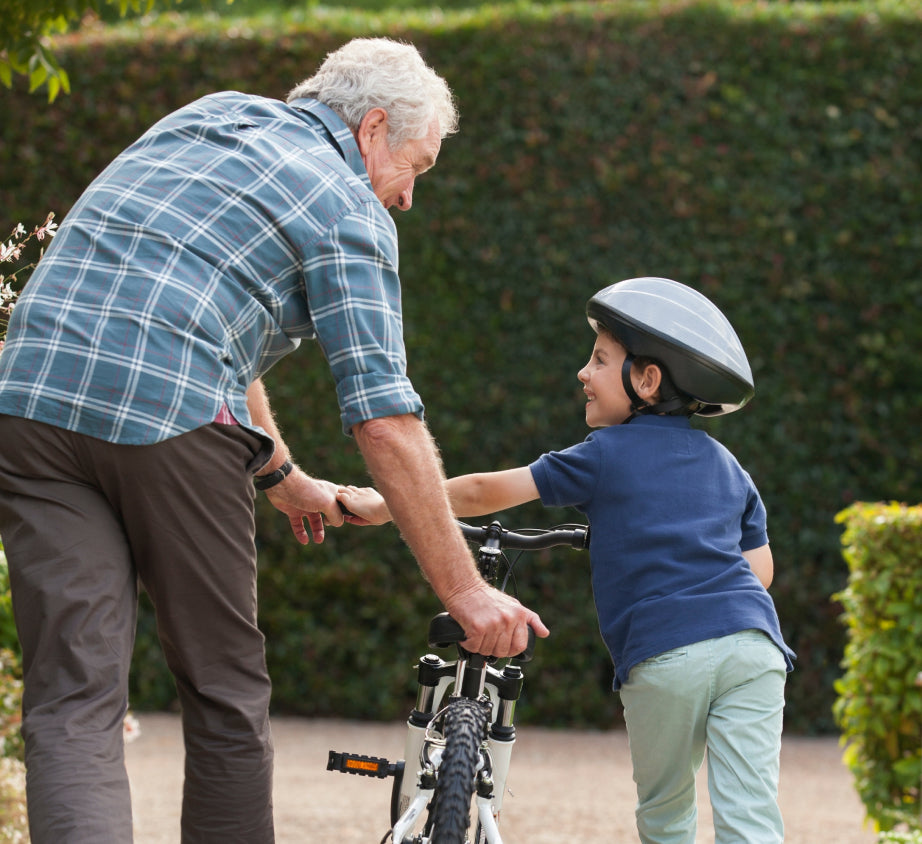 Grandfather teaching how to ride a bike